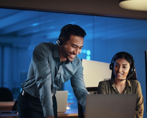 Side view of two people working on a laptop