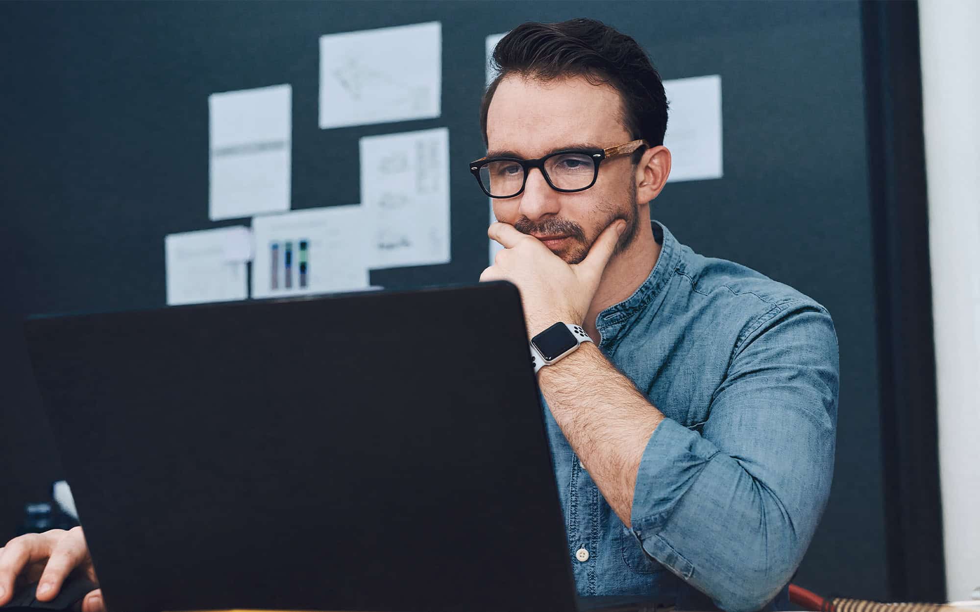 Front view of a man looking at a laptop